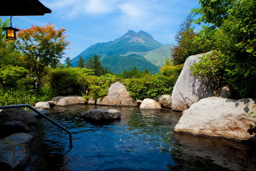 un charco de agua con una montaña en el fondo en Saigakukan, en Yufu