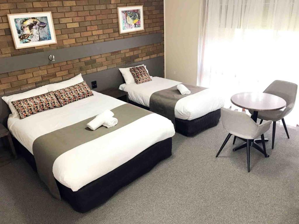 a hotel room with two beds and two tables at River Motel in Barham