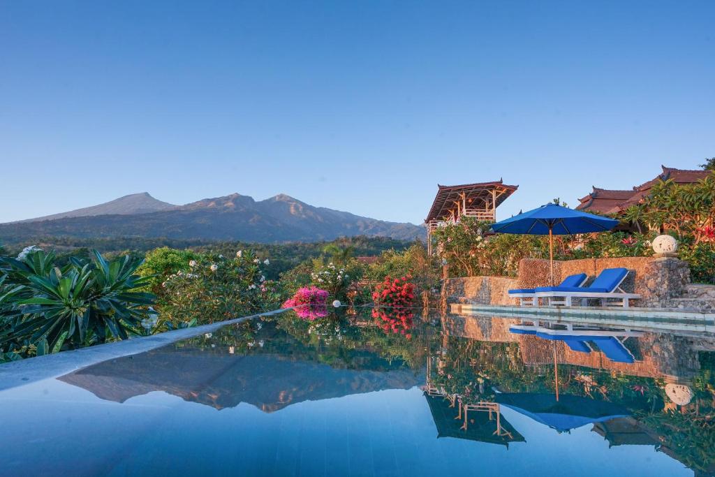 a swimming pool with a view of the mountains at Rinjani Lodge in Senaru