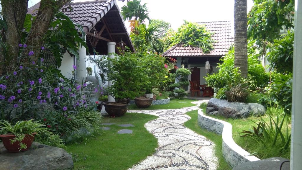einen Garten vor einem Haus mit Pflanzen in der Unterkunft Mekong Hotel & Restaurant in Ben Tre