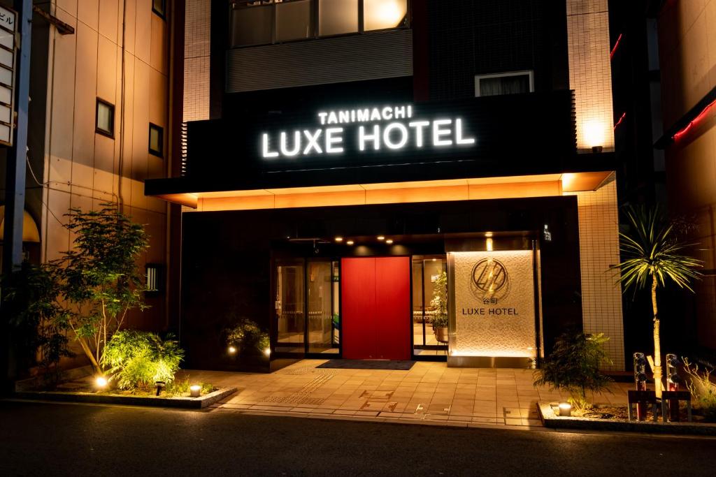 a hotel with a red door at night at Tanimachi LUXE HOTEL in Osaka