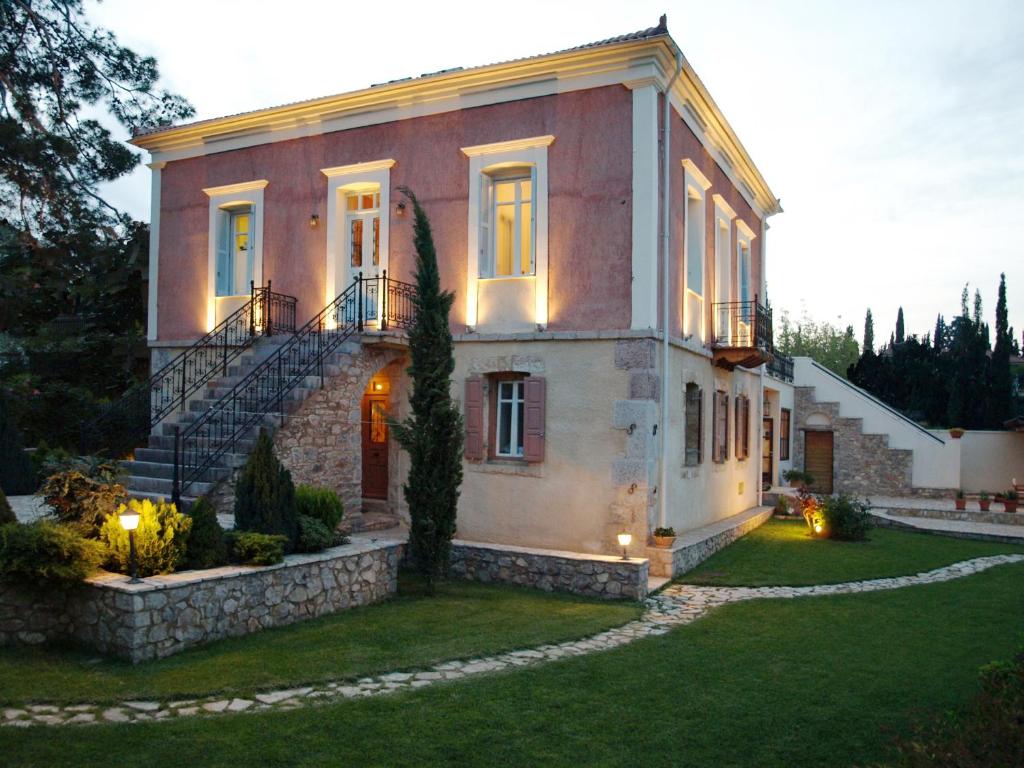 ein großes Haus mit einer Treppe im Hof in der Unterkunft Archontiko Parnassus Dadi in Amfikleia