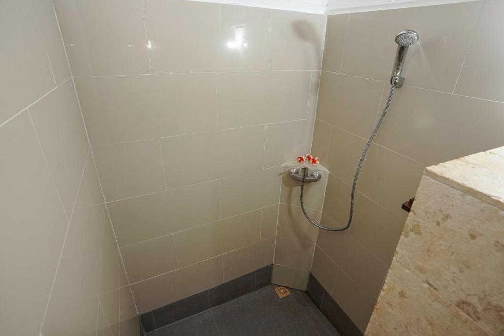 a shower stall with a shower head in a bathroom at Martas Hotel in Gili Trawangan
