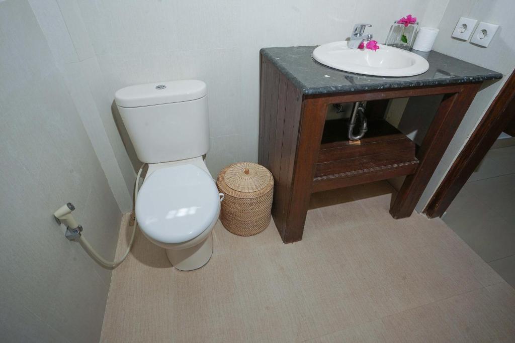 a bathroom with a white toilet and a sink at Martas Hotel in Gili Trawangan