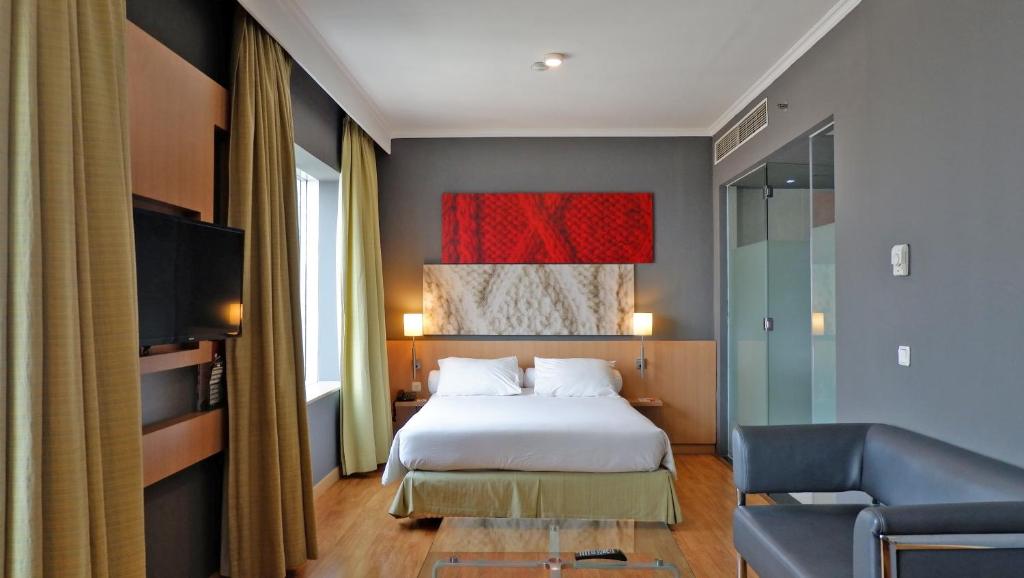 Rúm í herbergi á Hotel KIMAYA Slipi Jakarta By HARRIS