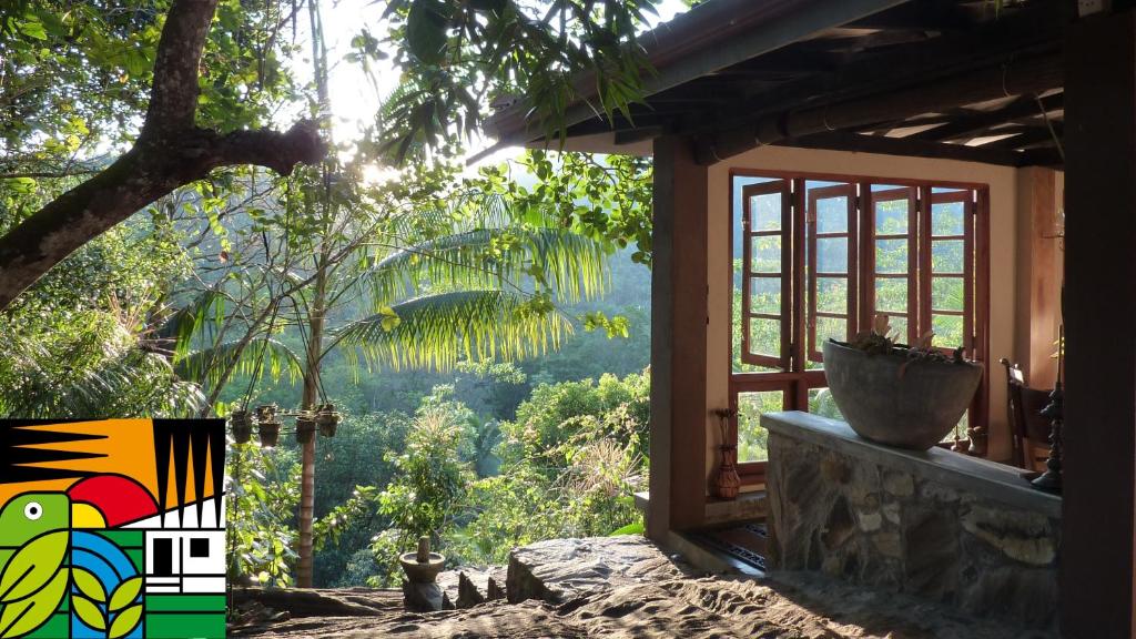 - une fenêtre d'une maison avec vue sur la forêt dans l'établissement Singharaja Garden AGRO ECO Lodge, à Pelawatta