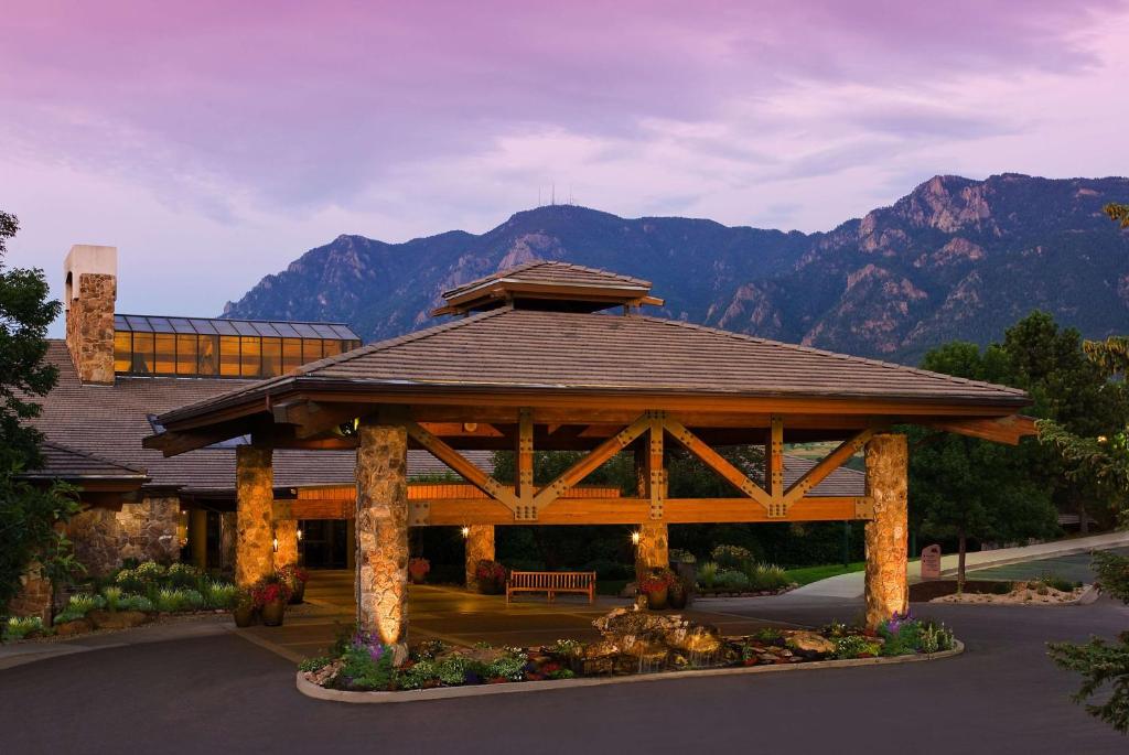 un cenador de madera con montañas en el fondo en Cheyenne Mountain Resort, a Dolce by Wyndham, en Colorado Springs