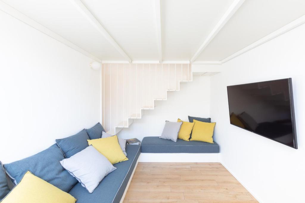 salon z niebieską kanapą i telewizorem w obiekcie Mini appartamento Colosseo w Rzymie