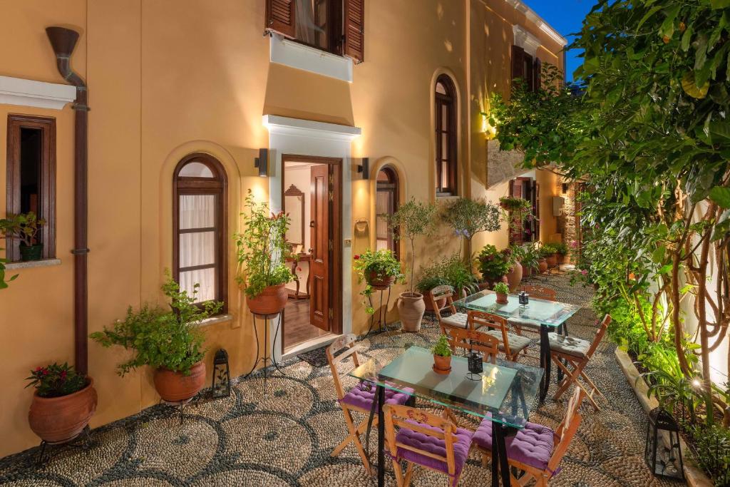 an outdoor patio with tables and chairs and plants at Rodos Niohori Elite Suites Boutique Hotel in Rhodes Town