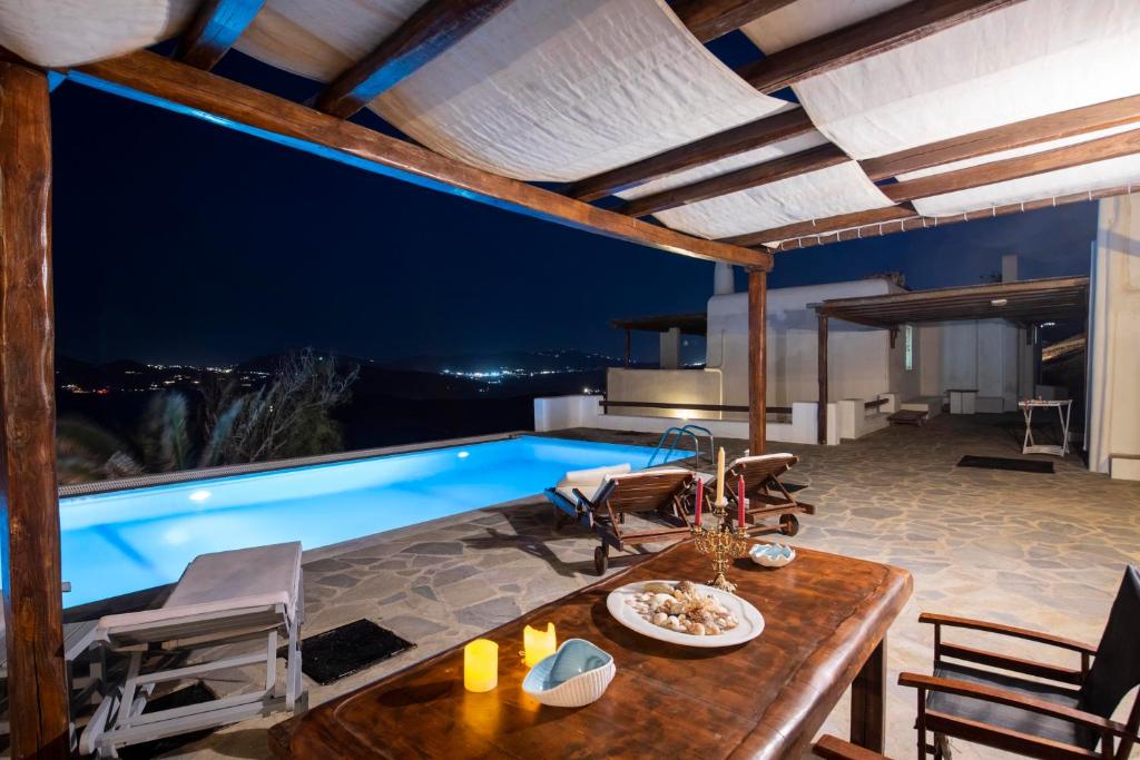 eine Villa mit einem Pool in der Nacht in der Unterkunft Siourdas Mykonos Villas in Agios Sostis Mykonos