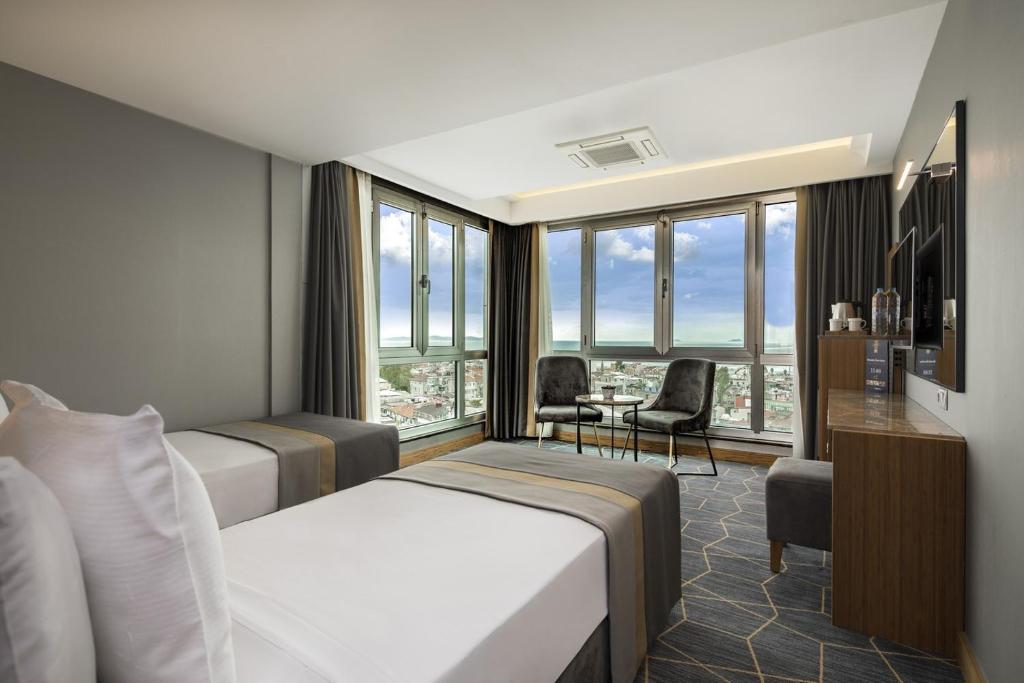 イスタンブールにあるホテル ヴェネラのベッド2台とデスクが備わるホテルルームです。