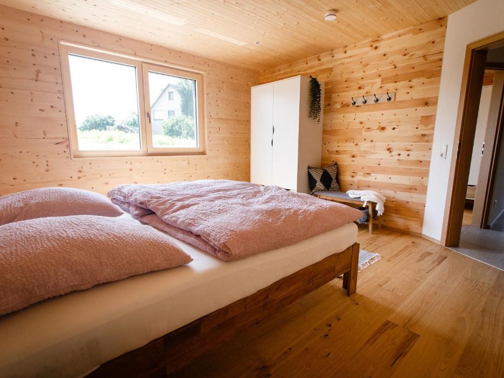 a bedroom with a bed in a wooden room at Ferienhaus zum See in Reichenau