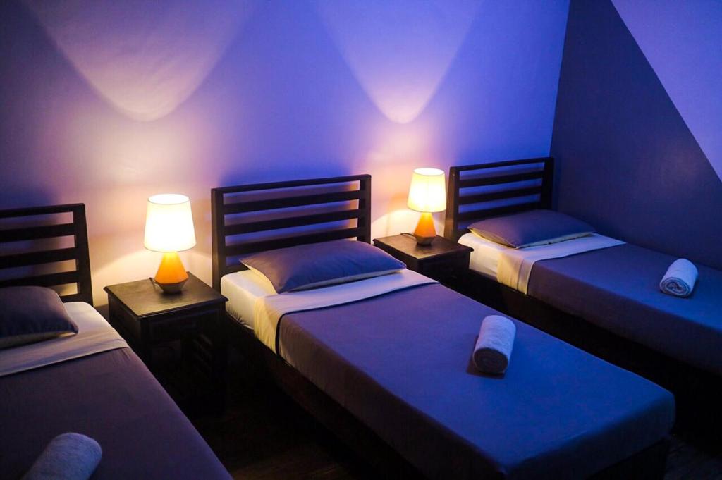a room with three beds with lights on them at Hostel Privado in Puerto Princesa City