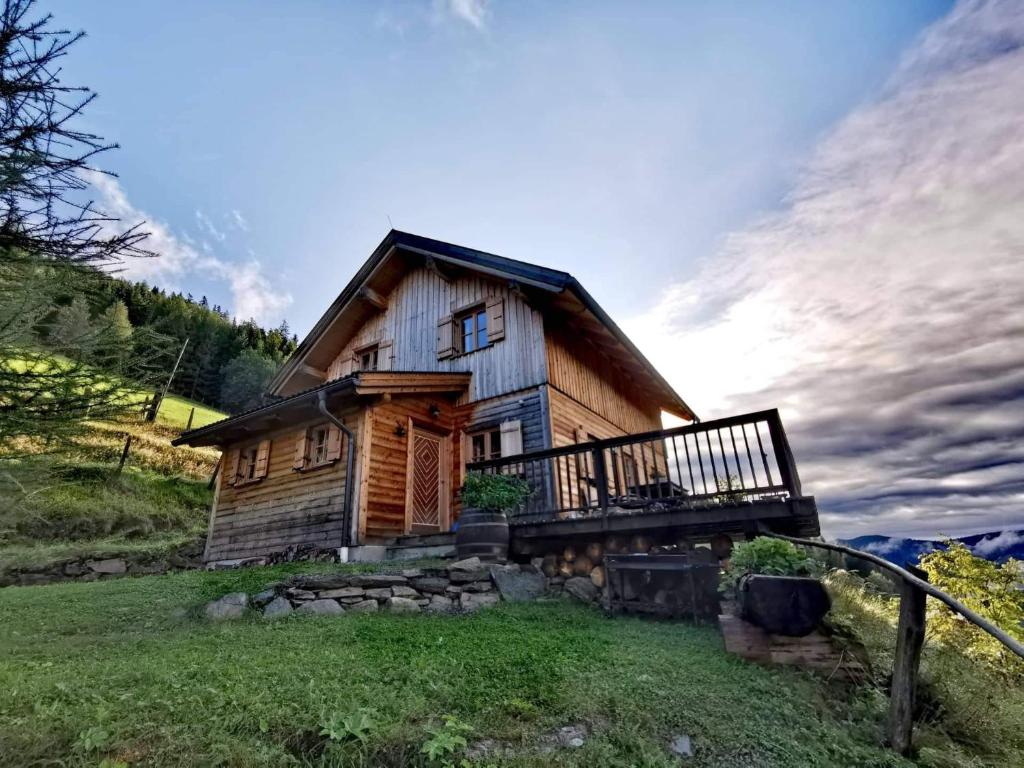 a wooden cabin with a porch on a grass field at Marhütte in Ebene Reichenau