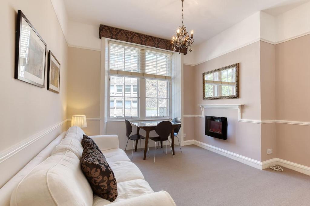 a living room with a white couch and a table at West Port - 2BR in the heart of the old town just off the Grassmarket in Edinburgh