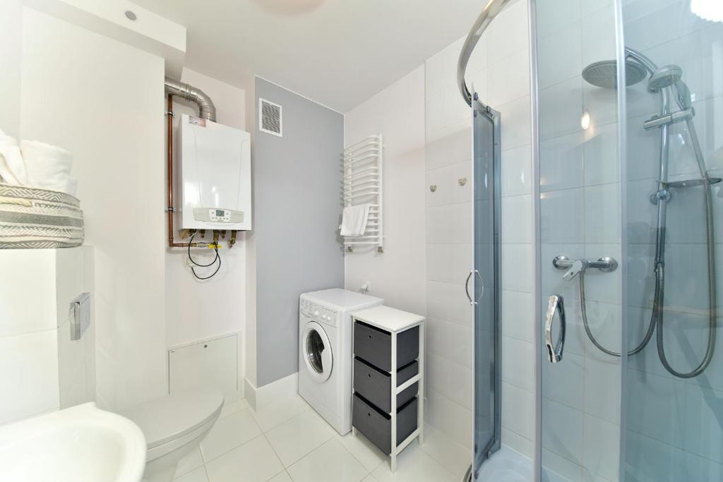 łazienka z prysznicem i pralką w obiekcie Apartament Szarotka - Apartamentuj w mieście Karpacz