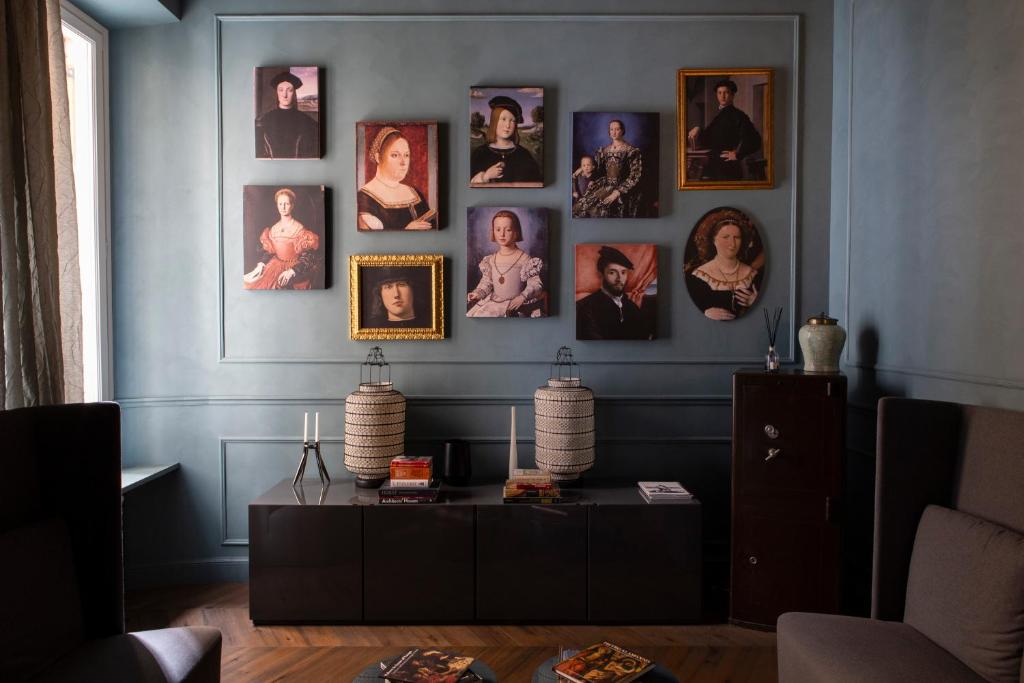 una sala de estar con retratos en una pared azul en Le Quattro Dame Luxury Suites, en Roma