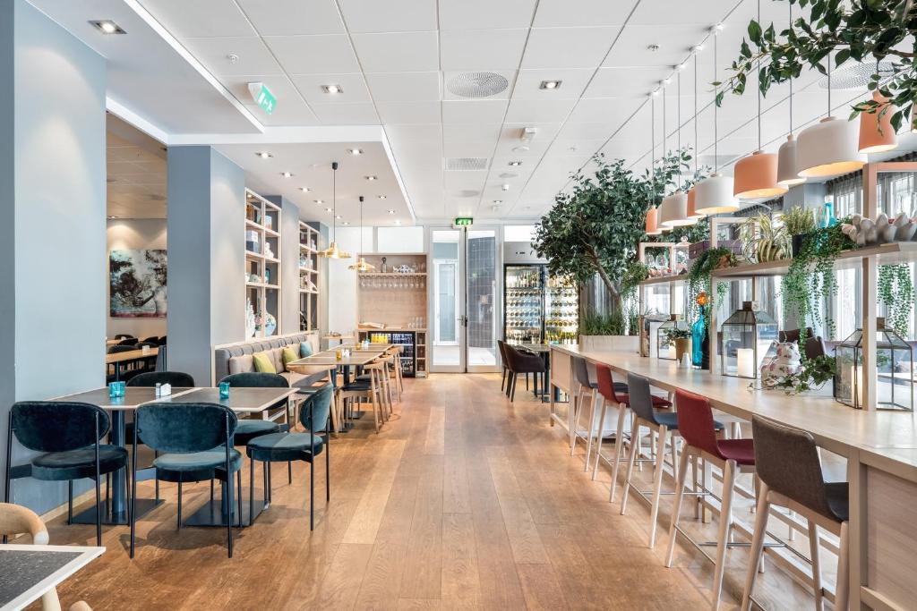 um restaurante com mesas e cadeiras e um bar em Quality Hotel Residence em Sandnes