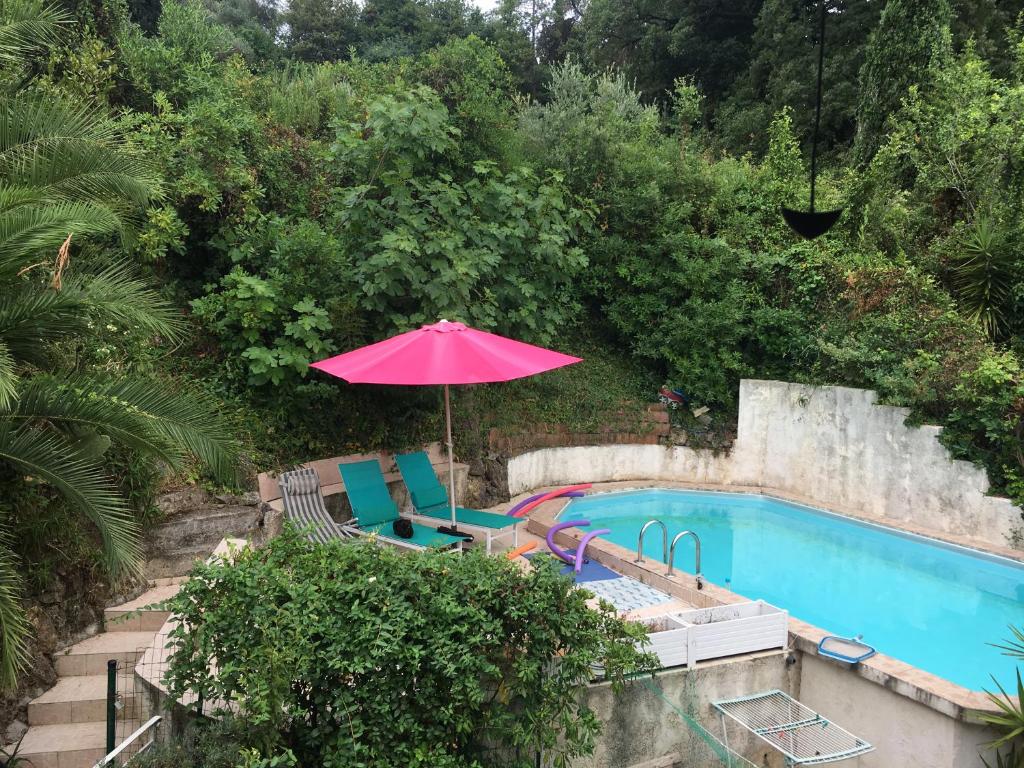 an umbrella and chairs next to a swimming pool at Le Cannet, Chambre à l'étage independant d'une maison avec piscine in Le Cannet