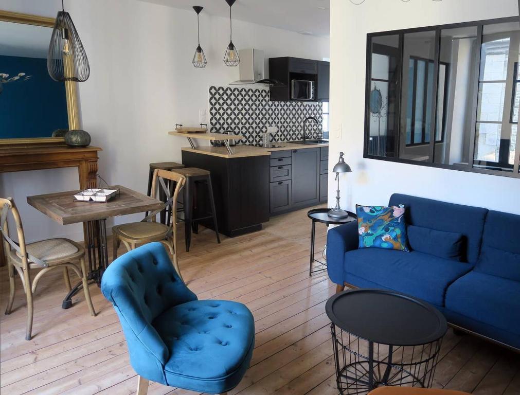 a living room with a blue couch and a table at L'atelier d'artiste charmant T2 centre historique in Dinan