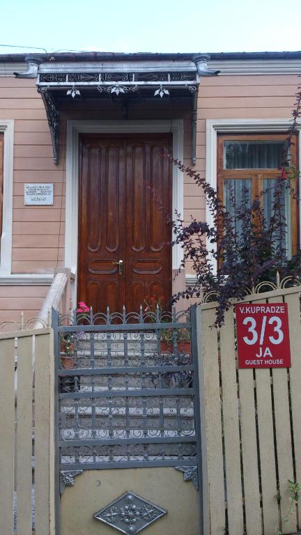 a house with a wooden door with a sign on it at JA in Kutaisi