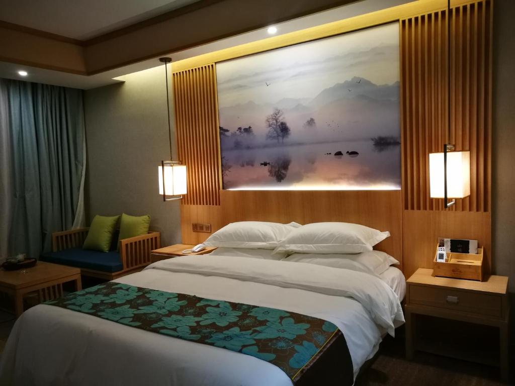 a bedroom with a large bed and a painting on the wall at Yunxianju Tea Culture Theme Hotel in Kunming