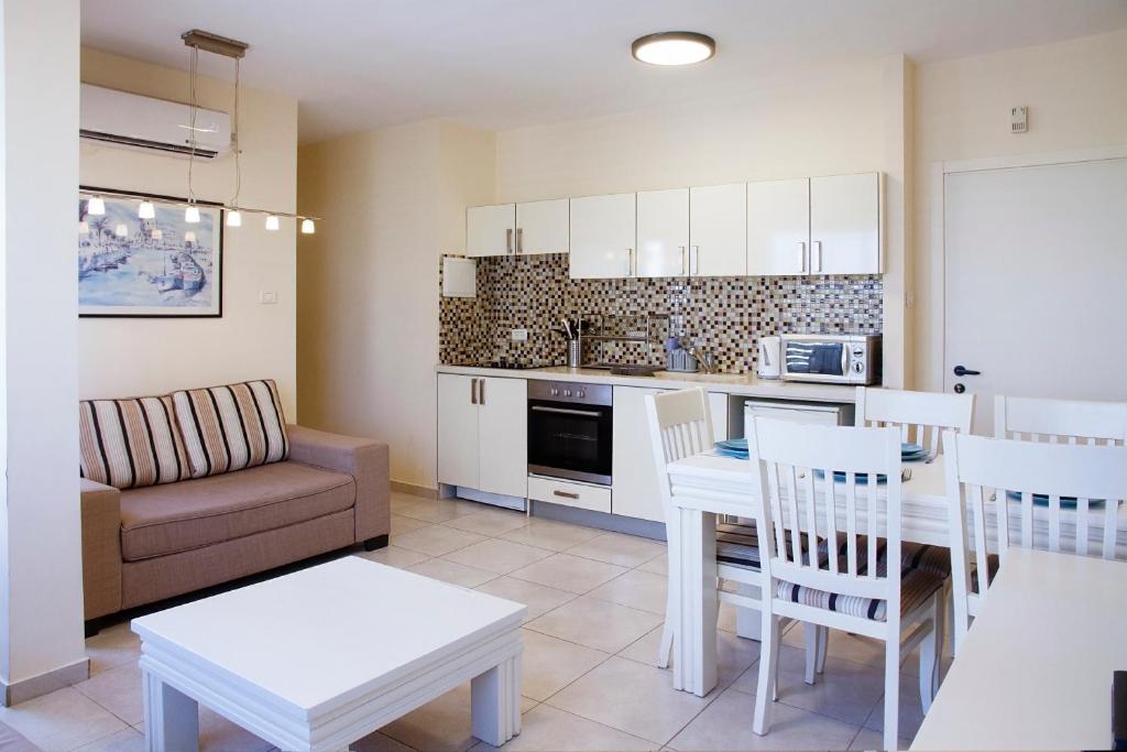 una cucina e un soggiorno con divano e tavolo di Apartments4you Bally a Bat Yam