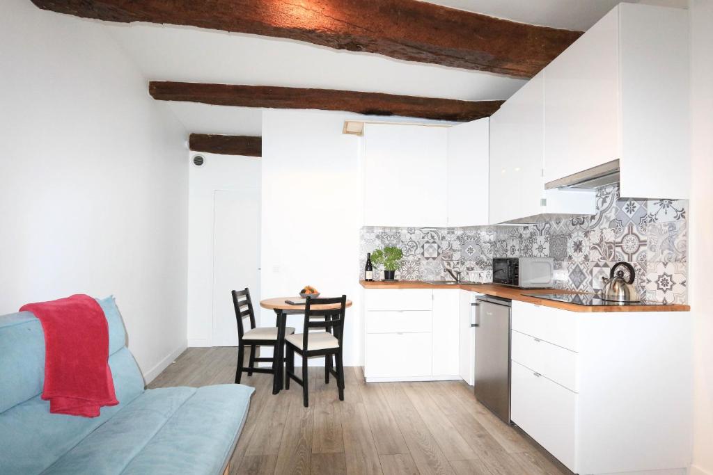 - une cuisine et une salle à manger avec des placards blancs et une table dans l'établissement ROGERIO en PLEIN CENTRE DE L'ISLE SUR SORGUE, à LʼIsle-sur-la-Sorgue