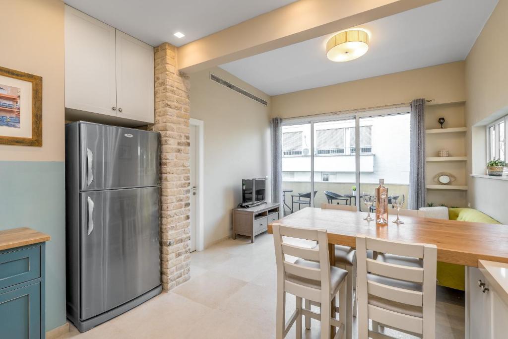 cocina y comedor con nevera y mesa en Ben-Gurion BLVD 2BDR close to the beach, en Tel Aviv
