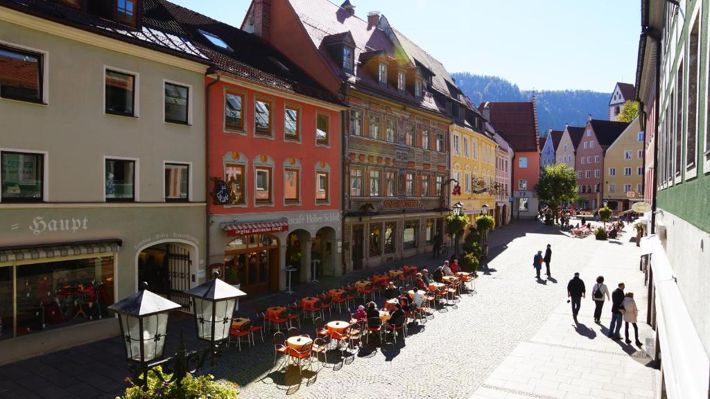 un grupo de personas caminando por una calle con edificios en Bavaria City Hostel - Design Hostel en Füssen