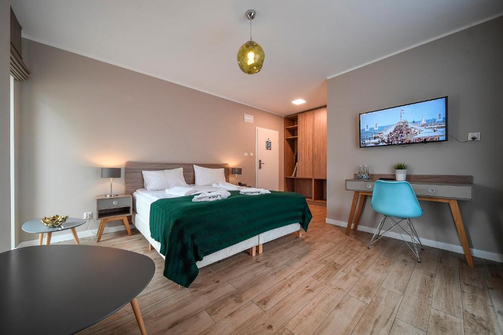 um quarto de hotel com uma cama e uma televisão na parede em PARK45 em Sopot