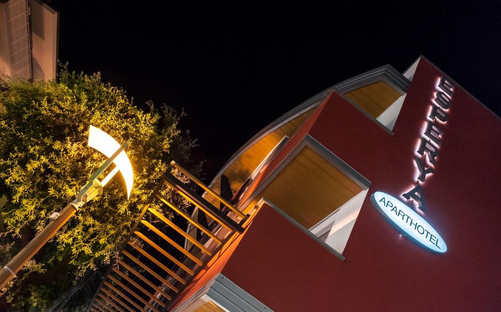 a building with a street sign on the side of it at Aparthotel Esperya in Lignano Sabbiadoro