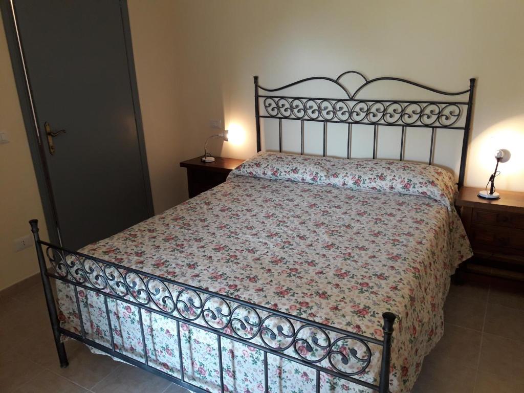 a bedroom with a bed with a floral comforter at Apartment Nonna Delia in Guardea