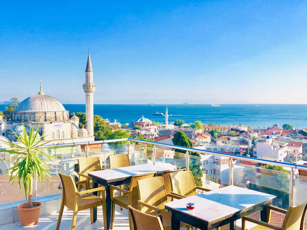 a balcony with tables and chairs and a mosque at Art City Hotel Istanbul in Istanbul