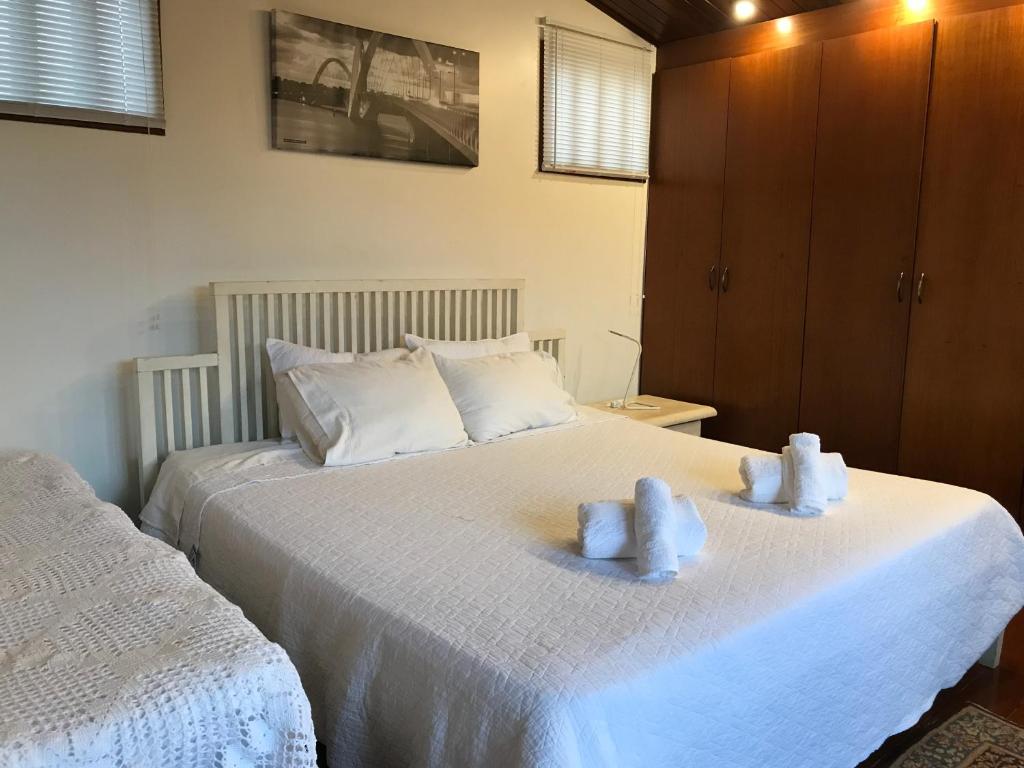 a bedroom with two beds with white towels on them at Casa da 17 - Lago Sul in Brasilia