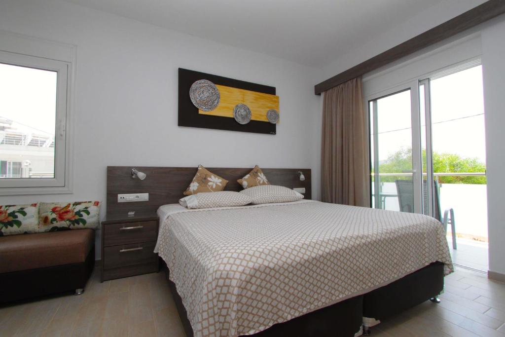 a bedroom with a bed and a couch and windows at Haraki Beauty in Haraki