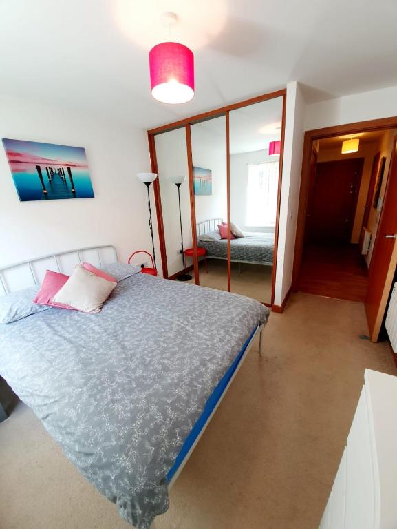 a bedroom with a bed and a room with a mirror at Southend Ground Floor Apartment with Parking in Southend-on-Sea