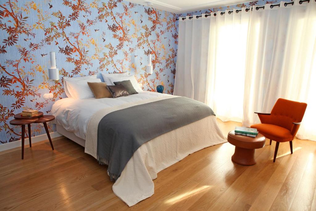 a bedroom with a bed and a chair at Águamel Sintra, Boutique Guest House in Sintra