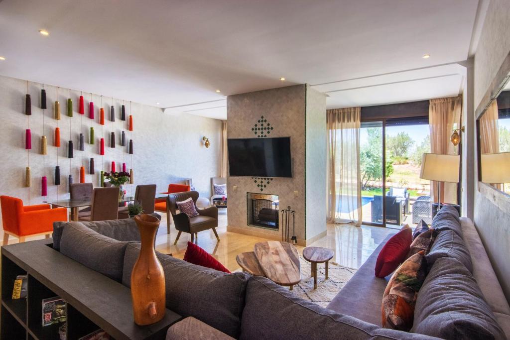 a living room with a couch and a tv at VILLA Waky & Golf - Jardin de l'Atlas in Marrakesh