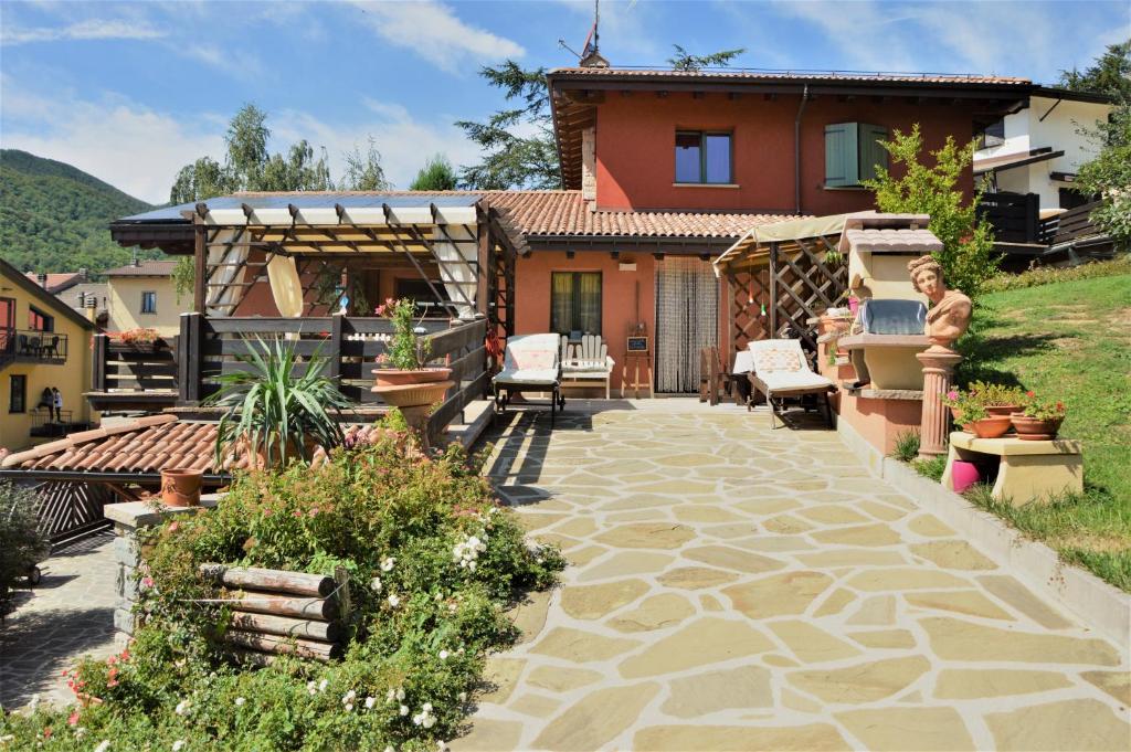 un cortile con patio in pietra e una casa di B&B La Piazzetta a Castiglione dei Pepoli