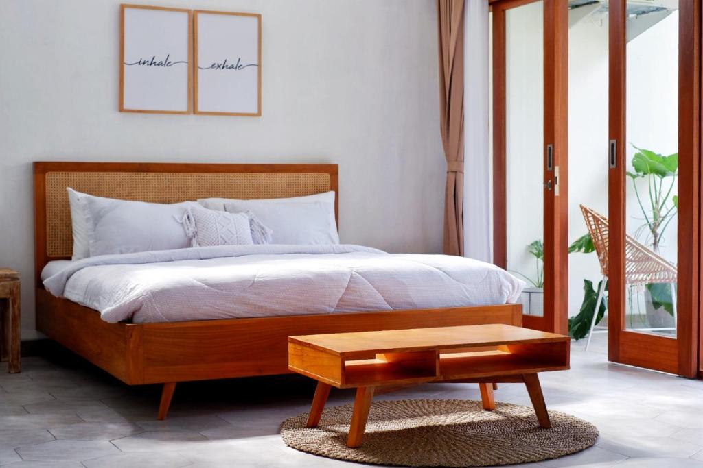 Schlafzimmer mit einem Bett und einem Couchtisch in der Unterkunft The Sloth Bali in Canggu