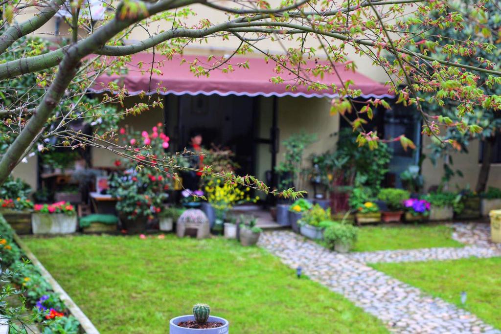 a garden with flowers and plants in a yard at 桐庐舍予民宿 Tonglu Sheyu Country House in Tonglu