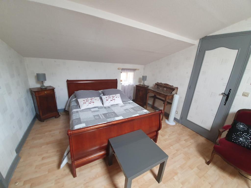 a bedroom with a bed and a table and a door at Chez Moutier in Monestier