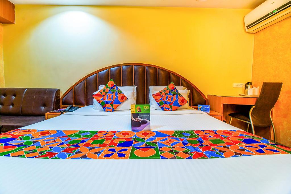 a hotel room with two beds with colorful pillows at FabHotel Palash Residency Ranchi Railway Station in Rānchī