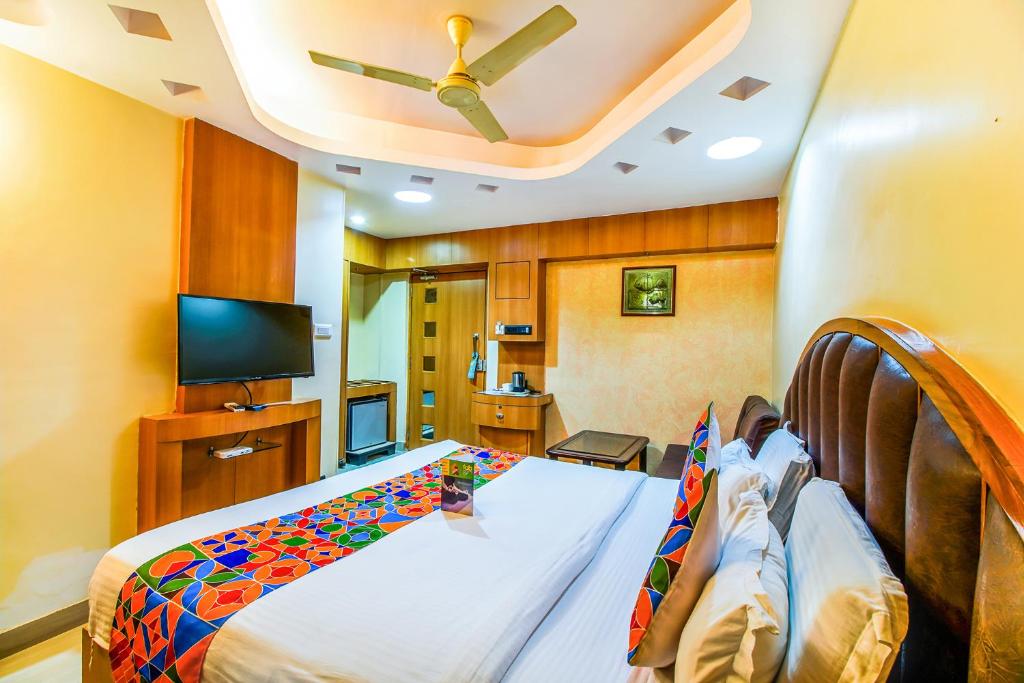 a bedroom with a bed and a flat screen tv at FabHotel Palash Residency Ranchi Railway Station in Rānchī
