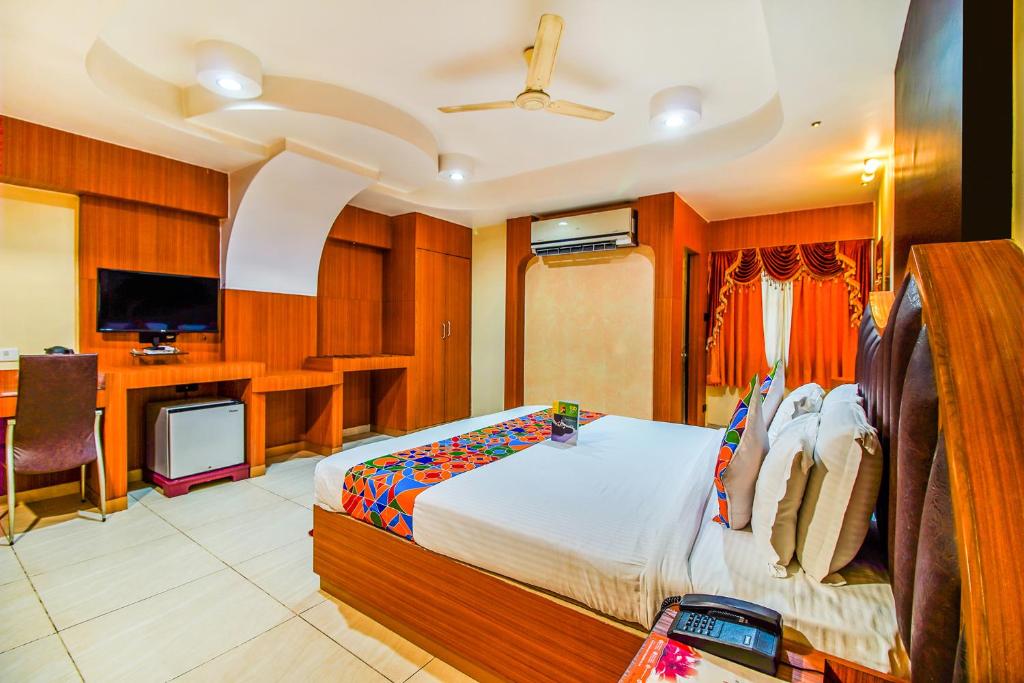 a bedroom with a bed and a desk and a television at FabHotel Palash Residency Ranchi Railway Station in Rānchī