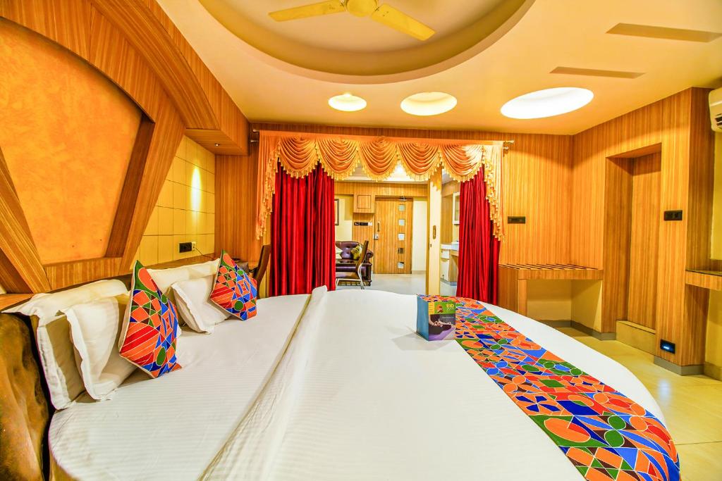 a large bed in a room with red curtains at FabHotel Palash Residency Ranchi Railway Station in Rānchī