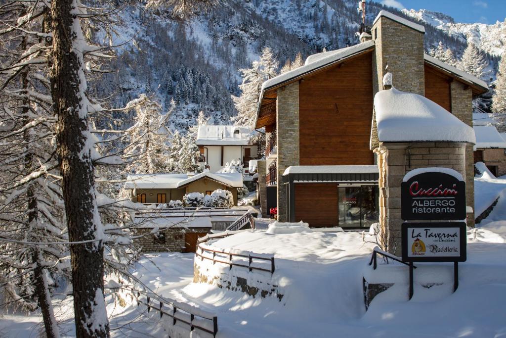 un rifugio da sci con un cartello sulla neve di Albergo Ristorante Cuccini a San Domenico