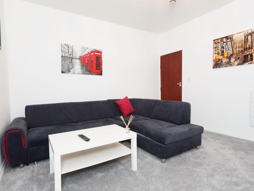 a living room with a blue couch and a white table at Ruth Apartments in Leeds