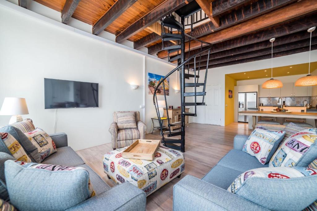 a living room with two blue chairs and a staircase at Punda City Centre Penthouse in Willemstad